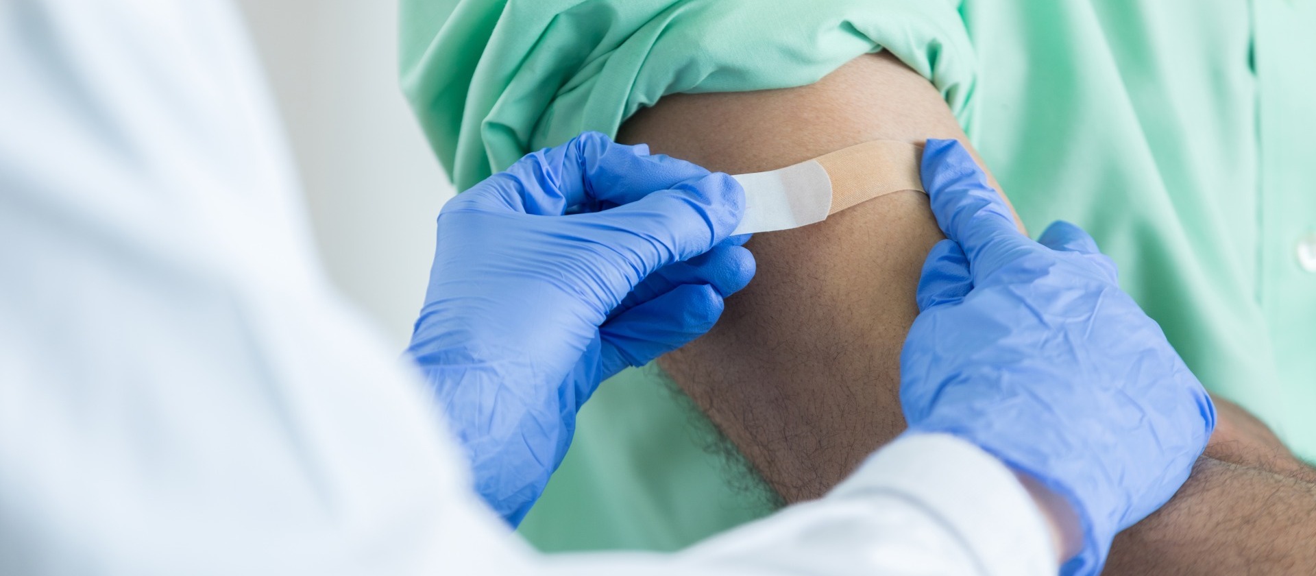 doctor-placing-bandaid-on injection-site