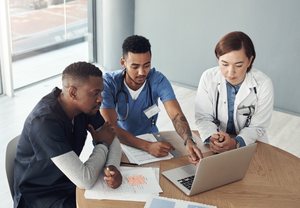Medical professionals around a laptop